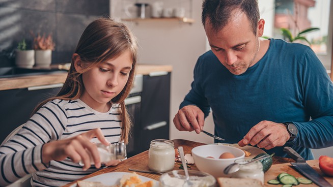 Father and daughter having breakfast together at home