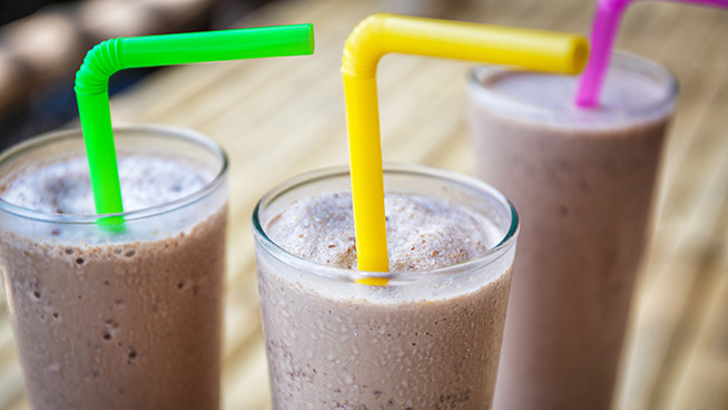 3 glasses with chocolate milkshake with colored straws