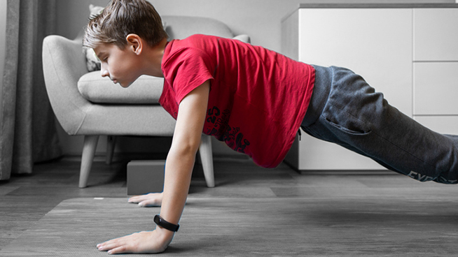 Small boy on yoga mat at home holding plank pose. Child physical activity at home on quarantine