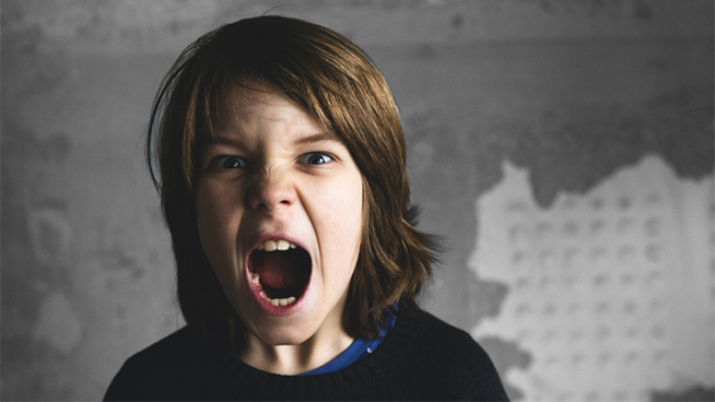 Boy screaming and looking at camera