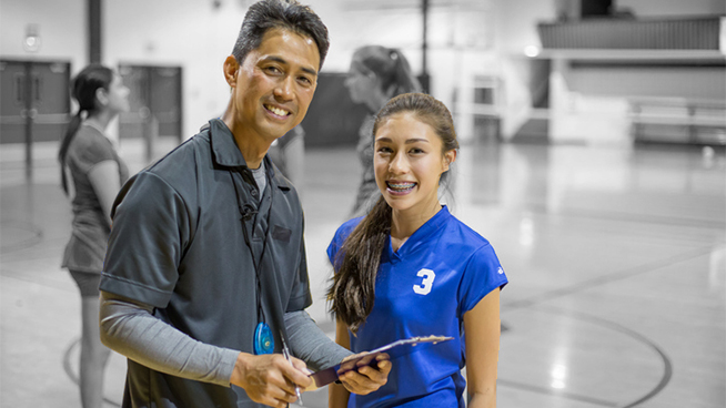 Girls volleyball player with coach