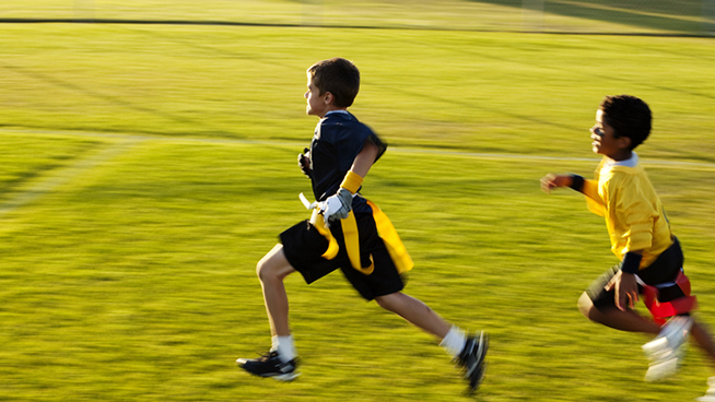 A young flag football player goes for the touchdown.