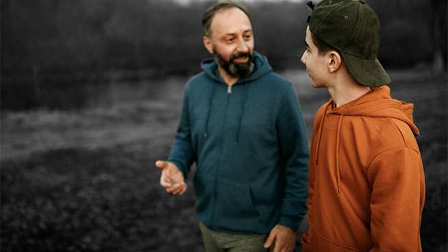 Mature man and his son walking in the public park