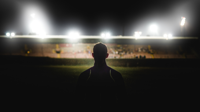 image of athlete looking at field with lights