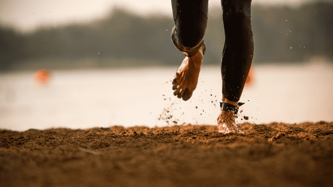close up image of a person running barefoot in dirt or sand - barefoot running exercises for runners - barefoot running excersises
