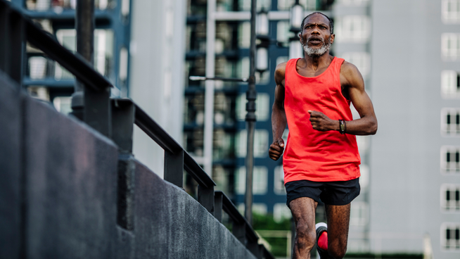 older athletic male running outside in the city - training for marathon and half-marathon