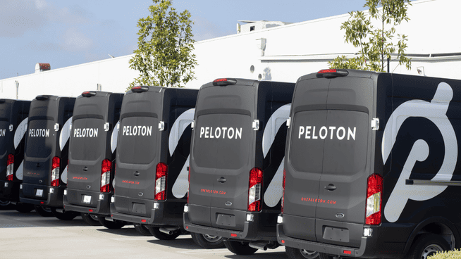a lot of peloton vans lined up outside of office building - peloton now selling on amazon