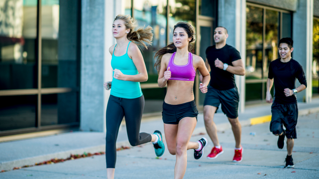 young male and female runners running on sidewalk in city - reduce injuries when running