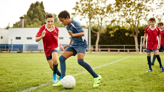 male soccer players competing in game on the soccer field