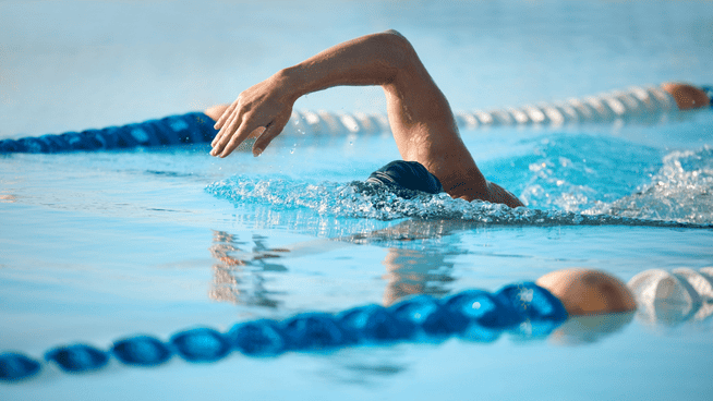 swimmer swimming laps in pool - should swimmers warm up in the water or on land? - warmups for swimmers