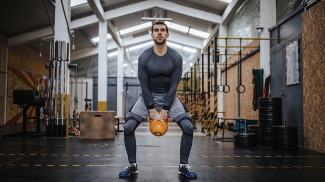 male athlete performing Kettlebell Swing at gym