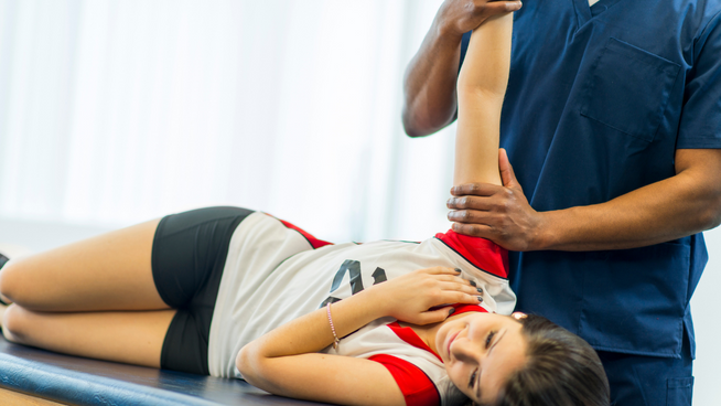 female youth athlete getting sports injury help from doctor