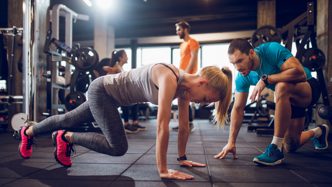 strength and conditioning coach working out a female athlete at the gym