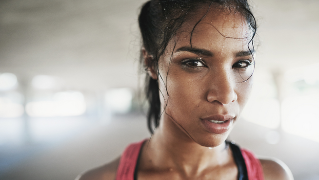 sweaty athletic woman staring straight into camera - mindset training and mental health in sports