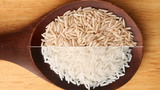large spoon showing half white rice and half brown rice - health benefits of white and brown rice