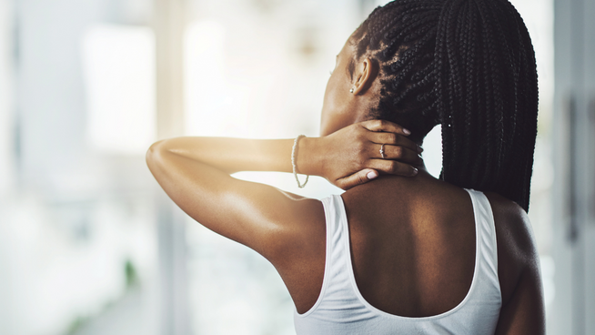 female athlete grabbing her neck from muscle stiffness from working out