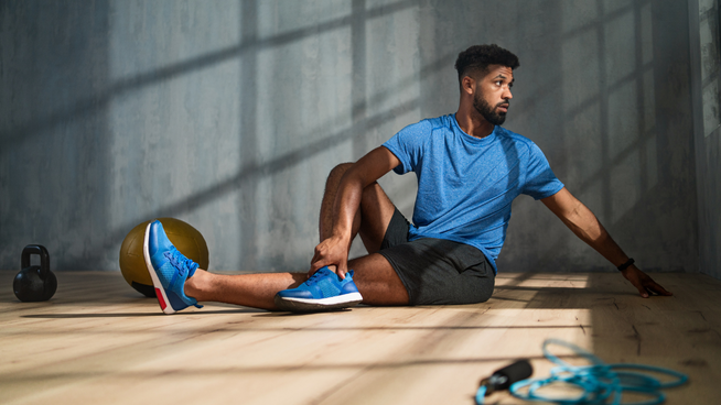 athletic male stretching at gym