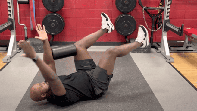 male performing deadbug exercize at gym