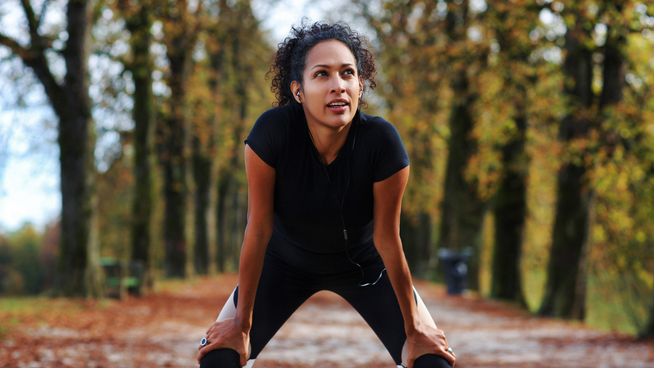 athletic woman jogging outside in nature to improve mental health