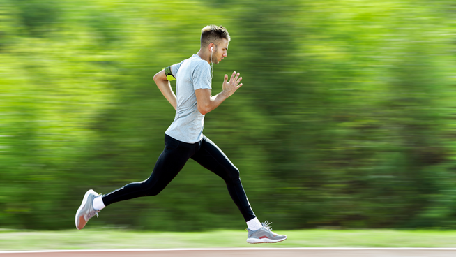 athletic male sprinting while running outside