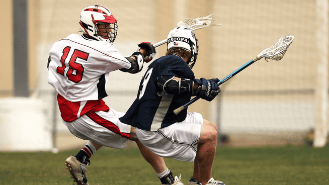 male lacrosse athletes playing in a game