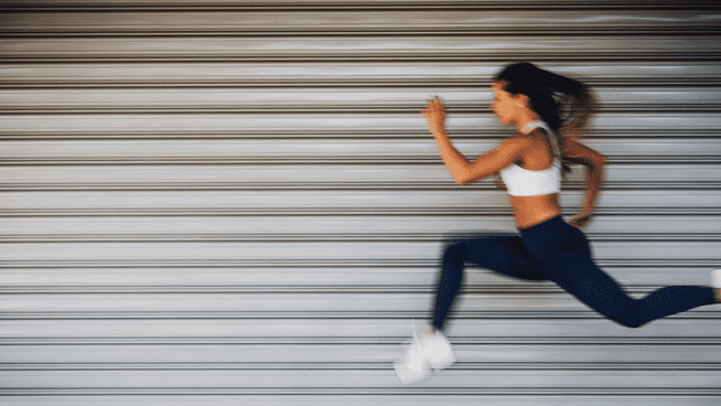 athletic woman sprinting fast outside