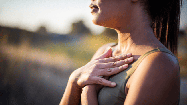 woman holding chest while breathing