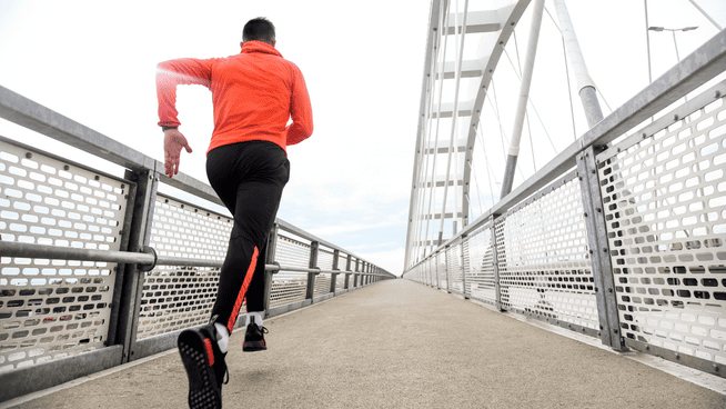 athletic male running on bridge during speed training session