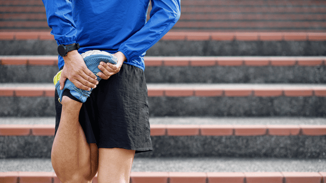 male runner stretching during warm up before a run