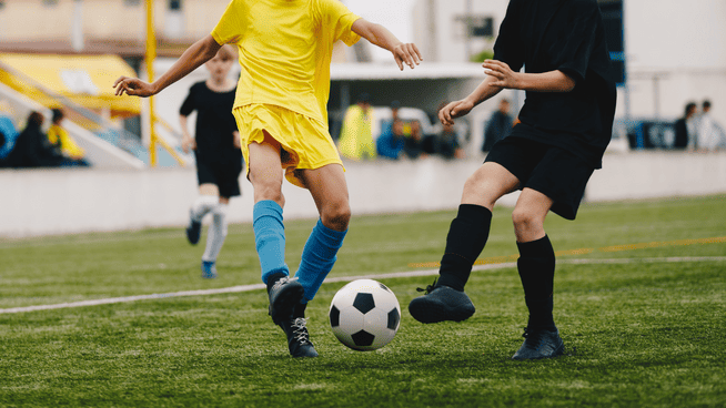 youth soccer players competing in a game