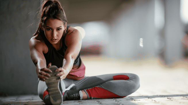 young athletic woman stretching before a run outside