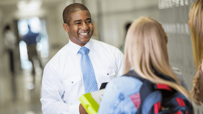 image of high school student and parent visiting with school staff or coach