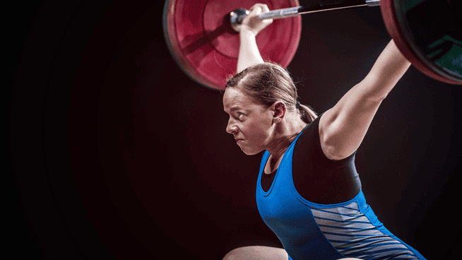athletic woman performing olympic weightlifting