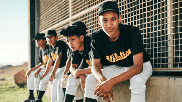 young male baseball players sitting on bench dealing with mental health