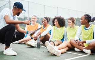 Image of coach talking with his athletes on basketball court