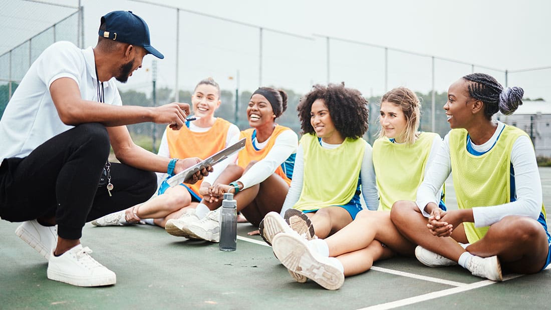 Image of coach talking with his athletes on basketball court