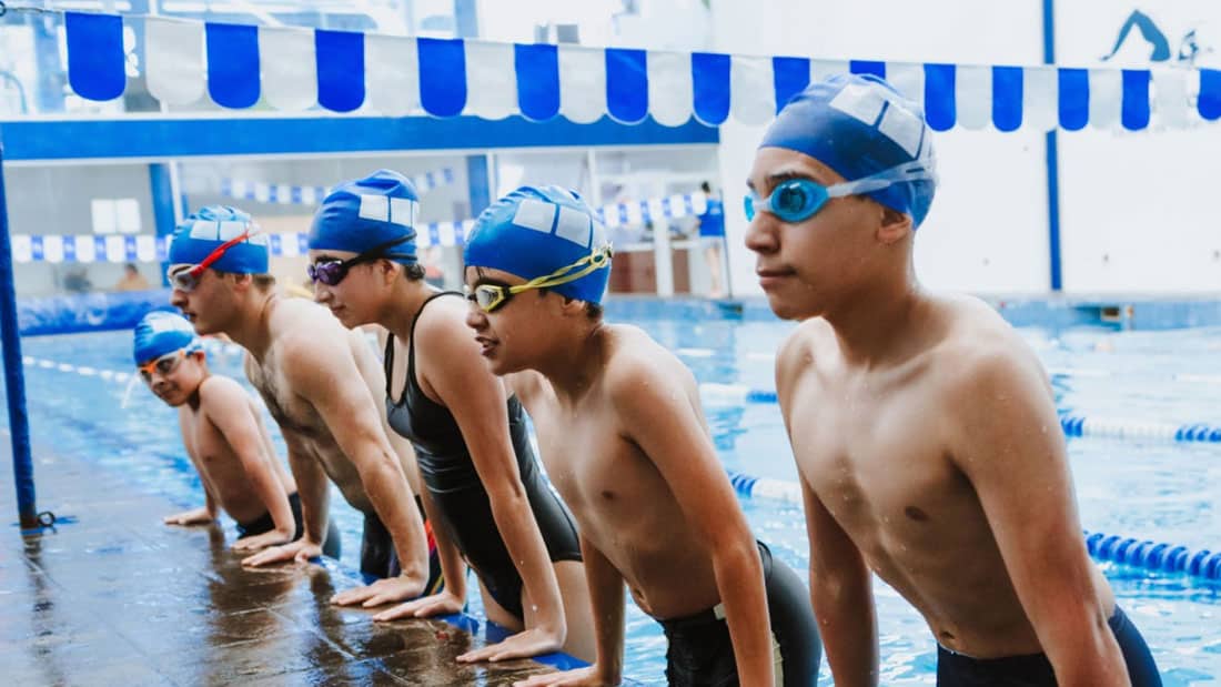 image of youth swimmers practicing together in pool